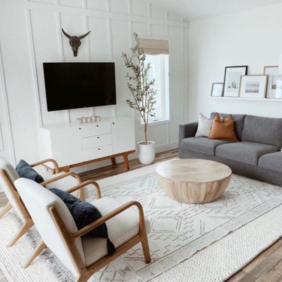 White wood paneling with layered rugs rustic transitional furniture for a decorated living room